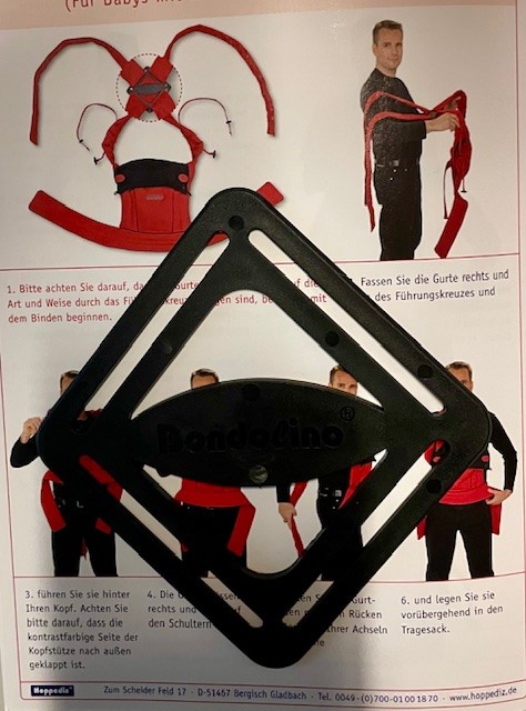 Kunststoffkreuz als Hilfe zum Anlegen bei MeiTais und anderen Tragehilfen mit überkreuzten Trägern